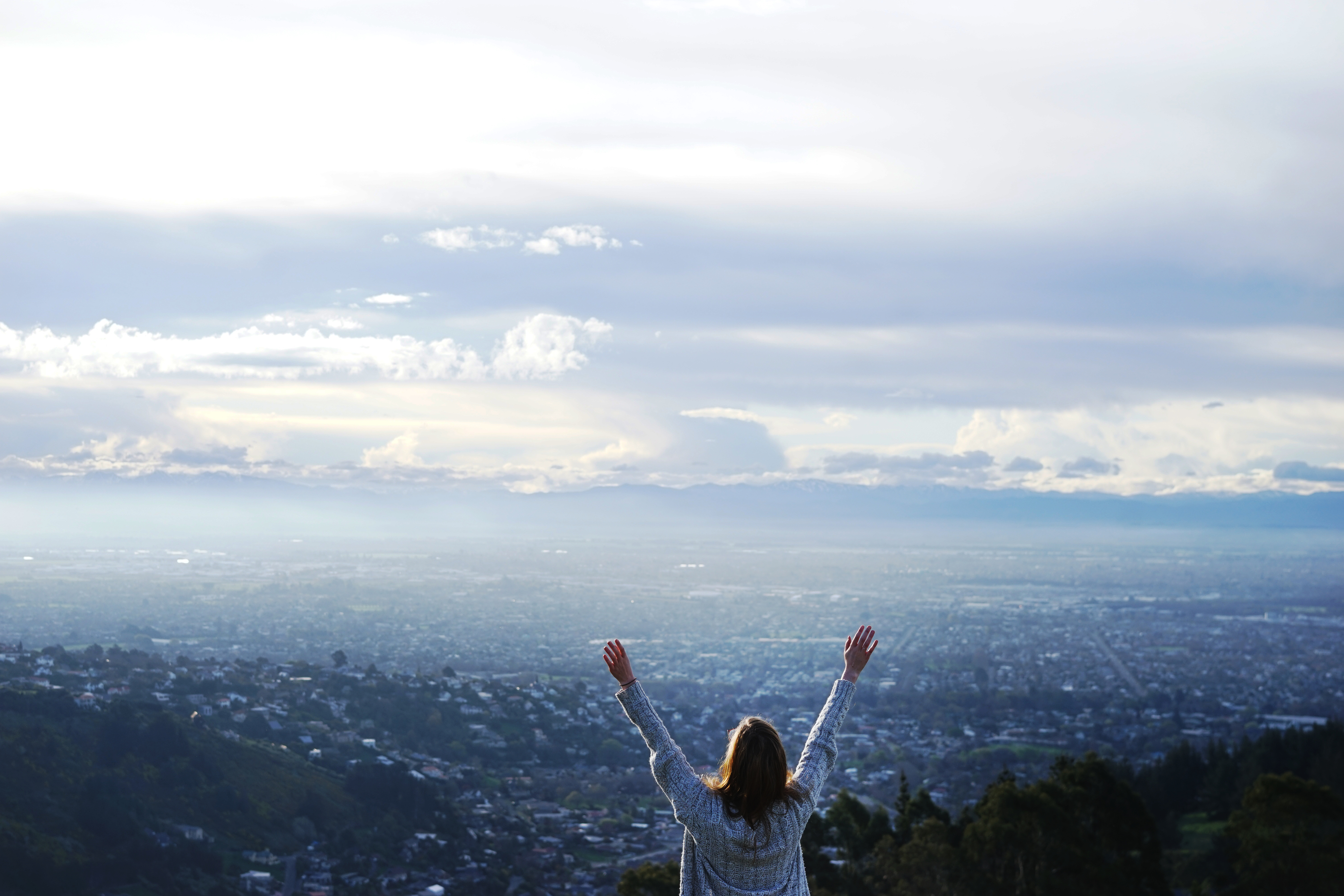 hands raised over a moutain wi